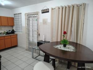 a kitchen with a table with a flower on it at Sleep relax v in Fajardo
