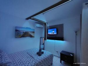 a bedroom with a bed and a television in it at Sleep relax v in Fajardo