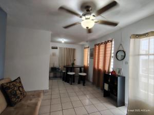 a living room with a ceiling fan and a table at Sleep relax v in Fajardo