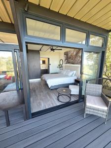 a master bedroom with a bed and a patio at Lazy Hill Eco Lodge in Warmbaths +23 photos