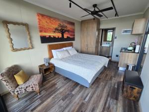 a bedroom with a bed and a chair at Lazy Hill Eco Lodge in Warmbaths