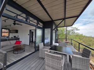 a patio with a couch and chairs on a deck at Lazy Hill Eco Lodge in Warmbaths