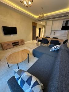 a living room with a blue couch and a table at Tatilçi Baba in Mekhrably +2 photos