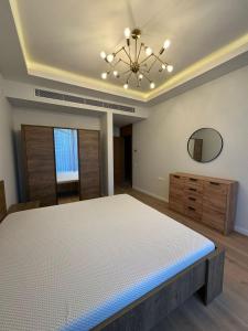 a large bedroom with a bed and a chandelier at Tatilçi Baba in Mekhrably
