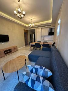 a living room with a blue couch and a table at Tatilçi Baba in Mekhrably