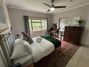 a bedroom with a bed and a dresser and a window at Cedara Way Cottage in Hilton