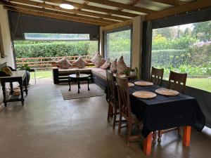 a dining room with a table and chairs and a couch at Cedara Way Cottage in Hilton
