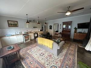 a living room with a couch and a kitchen at Cedara Way Cottage in Hilton +21 photos