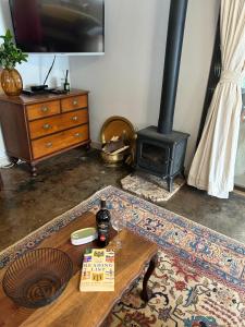 a living room with a table and a wood stove at Cedara Way Cottage in Hilton