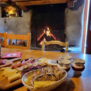 a table with a plate of food and a fireplace at Agri Scinghiöra in Brontallo