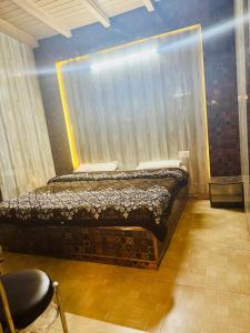 a bedroom with a bed and a window with a curtain at hotel sunshine in Nainital