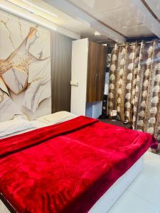 a bedroom with a red blanket on a bed at hotel sunshine in Nainital