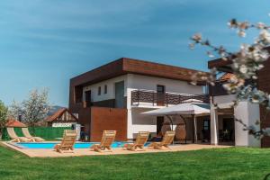 a group of chairs and a pool in front of a house at Villa Sunce in Visoko