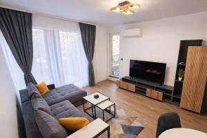 a living room with a couch and a tv at Boutique apartment 4 in Plovdiv