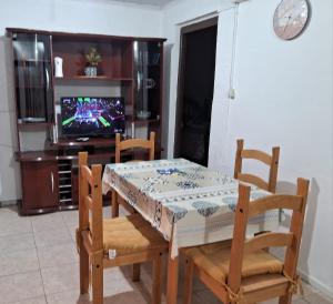 a dining room with a table and chairs and a television at Casita de Florida 2 in Florida
