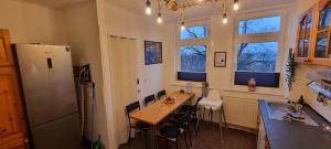 a kitchen with a wooden table and a refrigerator at Elite-Apartment am Hauptbahnhof Celle mit Küche,Privat-Parkplatz,Waschmaschine und 5G WLAN für 6 Personen in Celle