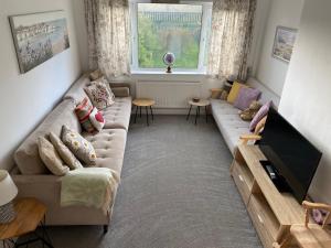a living room with a couch and a flat screen tv at Simla Bungalow, Tetney, Spacious Parking, Private Garden in Tetney