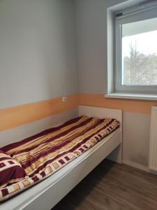 a bed in a room with a window at Apartament Ela in Żywiec