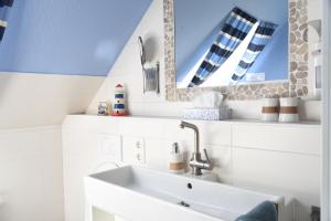 a bathroom with a sink and a mirror at Ferienwohnung Ankerpladsen Jolle in Behrensdorf +14 photos