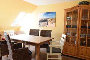 a dining room with a wooden table and chairs at Ferienwohnung Ankerpladsen Jolle in Behrensdorf