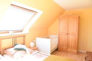 a bedroom with a bed and a window and a crib at Ferienwohnung Ankerpladsen Jolle in Behrensdorf