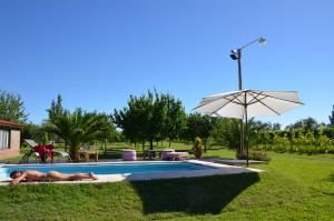 two people laying in the grass by a swimming pool at Finca Fisterra in Maipú