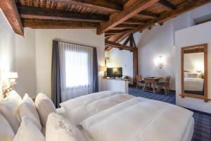 a bedroom with a large white bed and a table at Soldanella by Hotel Adula in Flims +63 photos