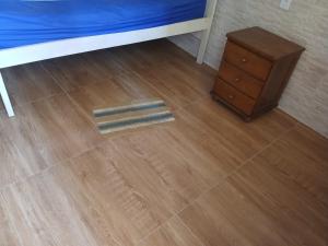 a wooden floor with a bed and a night stand at Pousada Coutinho in Paraty