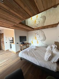 a bedroom with a bed with a painting on the wall at L'évasion in Saint-Jean-dʼArvey