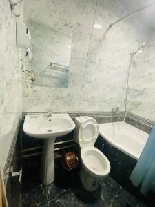 a bathroom with a toilet and a sink and a tub at Guest house Afsona old city in Bukhara +37 photos
