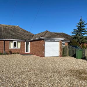 a red brick house with a white garage at Simla Bungalow, Tetney, Spacious Parking, Private Garden in Tetney