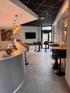 a restaurant with a bar with tables and chairs at Sous Les Pins in Étoile-sur-Rhône