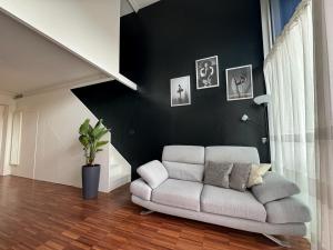 a living room with a couch and a black wall at Private Luxury Loft in Crescenzago