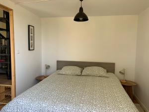 a bedroom with a bed and two tables and a lamp at Serenane in Saint-André-de-Najac