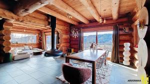 a living room with a table and a fireplace in a log cabin at Chalet Trappeur 8 Personnes in Beaune