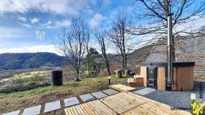 a wooden deck with a building on top of a hill at Chalet Trappeur 8 Personnes in Beaune