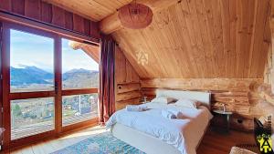 a bedroom with a bed and a large window at Chalet Trappeur 8 Personnes in Beaune