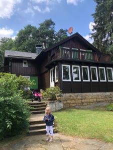 a little girl standing in front of a house at Haus Schrammsteinblick in Ostrau