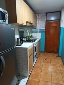 a small kitchen with a stove and a refrigerator at MNk HOTEL in Arequipa