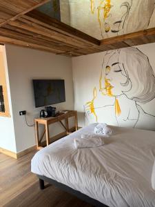 a bedroom with a bed with a painting on the wall at L'évasion in Saint-Jean-dʼArvey