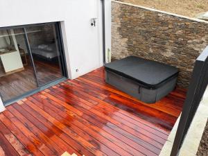a suitcase sitting on a deck next to a door at L'évasion in Saint-Jean-dʼArvey +1 photo