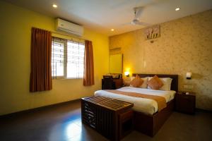 a bedroom with a large bed and a window at Hotel Arunachala in Tiruvannāmalai