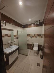 a bathroom with a shower and a sink and a toilet at فندق تاج النخبة - Taj Nakhba Hotel in Jazan