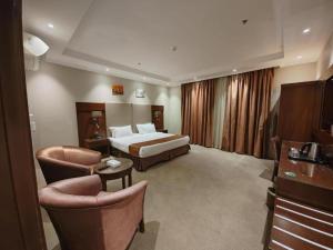 a hotel room with a bed and two chairs at فندق تاج النخبة - Taj Nakhba Hotel in Jazan