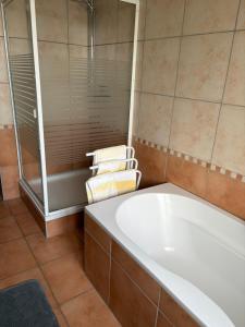 a bathroom with a bath tub and a shower at Appartement à l'ange in Climbach +25 photos