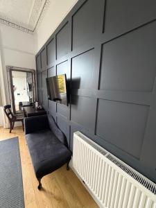 a living room with a black wall and a chair at Edinburgh37 in Edinburgh