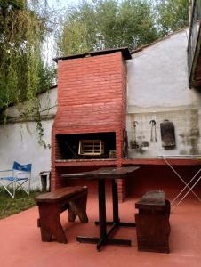 a brick house with a table and a stove at Depto Brochero in Mina Clavero