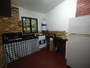 a kitchen with a white refrigerator and a sink at Depto Brochero in Mina Clavero