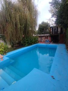 a large blue swimming pool in a yard at Depto Brochero in Mina Clavero