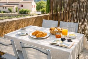 a table with a breakfast of croissants and orange juice at Gîte Le Verdon in Quinson